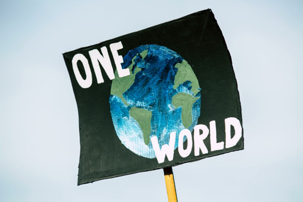 image représentant un panneau sur lequel est écrit "One World" avec le dessin de la Terre.